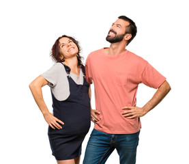 Obraz premium Couple with pregnant woman posing with arms at hip and laughing on isolated white background