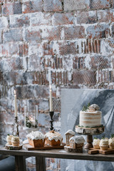 Christmas decorated dessert table with a variety of pastries, gingerbread house, cake and candles