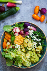 Buddha bowl with mixed roast and fresh vegetables, hummus and miso dressing