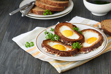 Baked toasts with egg filling and fresh parsley on a plate    