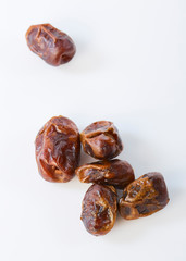 Dried halawi dates on a white