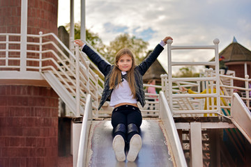 little girl riding down hill on the playground