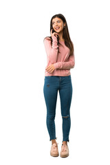 A full-length shot of a Teenager girl with pink shirt thinking an idea while looking up