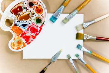 several paintbrushes with paint on a table