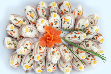 Close up of small canapes arranged on a plate over light background - selective focus