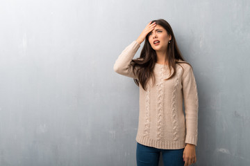 Teenager girl with sweater on a vintage wall with surprise and shocked facial expression