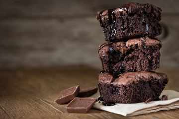 A stack of chocolate brownies on wooden background with mint leaf on top, homemade bakery and dessert
