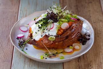 Sweet potato with mashed avocado, yogurt and sprouts