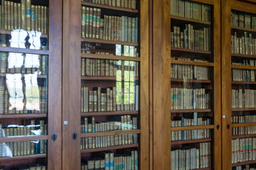 Glass reflection of old bookcase in an ancient library