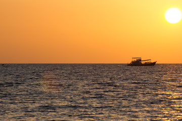 Boot f&auml;hrt auf dem Meer in Thailand dem Sonnenuntergang entgegen