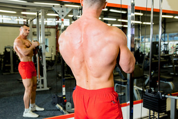 male bodybuilder doing exercises in a gym