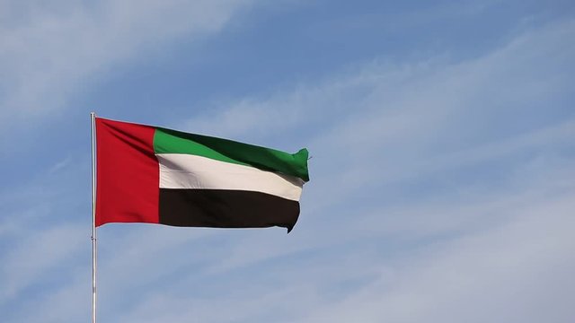 UAE flag waving in the sky, national symbol of UAE. UAE National Day. UAE flag day.