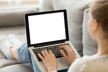 Close up of female sit on cozy sofa writing email on laptop, girl freelancer working at computer from home, focused student studying un bed, woman texting with friend or writing message to colleague
