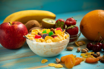 Tasty cornflakes with milk and fruits  in glass bowl 