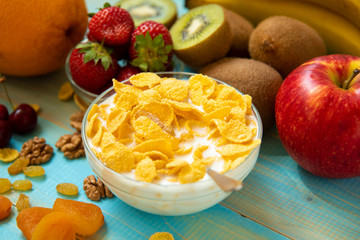 Tasty cornflakes with milk and fruits  in glass bowl 