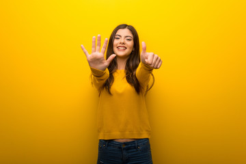 Teenager girl on vibrant yellow background counting six with fingers