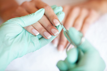 Woman Hand Care. Closeup Of Beautiful Female Hands Having Spa Manicure At Beauty Salon. Beautician Filing Clients Healthy Natural Nails With Nail File. Nail Treatment