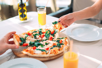 Obraz na płótnie Canvas Eating Pizza. Hands close-up take pieces of pizza.