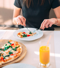 Obraz na płótnie Canvas Young Girl eating Pizza in a Restaurant.