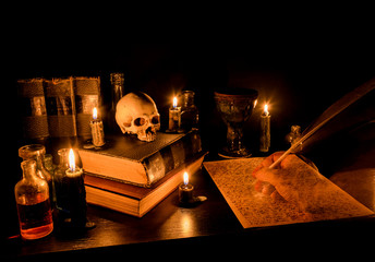 Wizard's Desk. A desk lit by candle light. A human skull, old books, a goblet, and potion bottles...