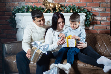 Christmas photo of happy family around a decorated Christmas tree. Family celebrates New year