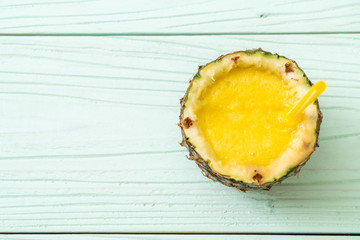 fresh pineapple smoothie glass on wood table