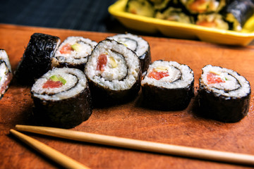 sushi rolls on wooden plank