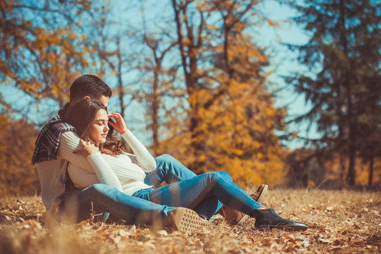 Romantic couple hugging and sitting in the park