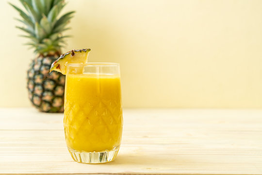 fresh pineapple smoothie glass on wood table