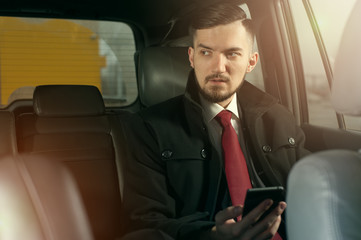 Young handsome businessman sitting in the car