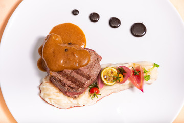 Pepper steak, served with potatoes, strawberry and cherry tomato