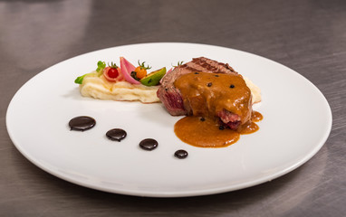 Pepper steak, served with potatoes, strawberry and cherry tomato