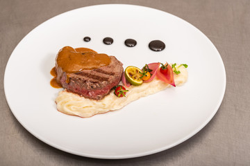 Pepper steak, served with potatoes, strawberry and cherry tomato