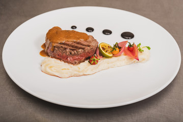 Pepper steak, served with potatoes, strawberry and cherry tomato