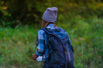 Young woman walking alone in the woods. Hiking concept in the mountain in summer