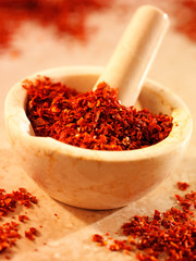 RED PEPPER FLAKES IN PESTLE AND MORTAR