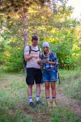 Obraz premium Young couple walking in the forest. Hiking concept in the mountain in summer