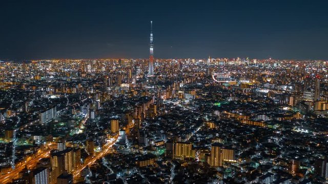 Aerial night hyper lapse of Tokyo Skytree tower with Tokyo city in background.Tokyo Skytree is a broadcasting, restaurant and observation tower in Sumida Japan.