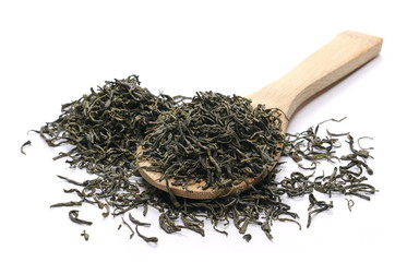 Green tea leaves in wooden spoon isolated on white