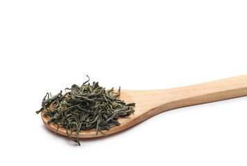 Green tea leaves in wooden spoon isolated on white