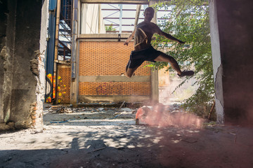 Free runner exercising around colorful smoke bomb