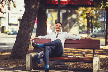 Fototapeta premium Young businessman is outdoors, relaxing and enjoying in the park