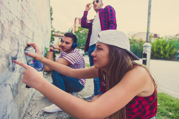 Young careless people trying to do graffiti