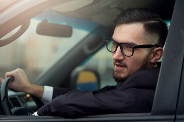 Young businessman driving luxury car.