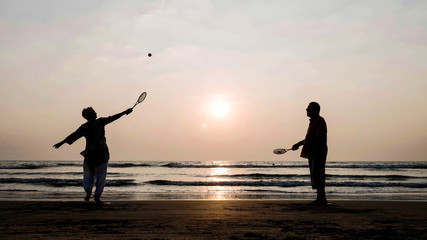 Fototapeta premium Active senior couple playing tai chi ballon ball at the beach.