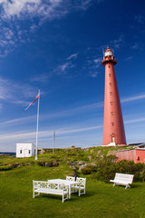 Andenes lighthouse with picnic benches and Norweigen flag, Vesteralen, Norway