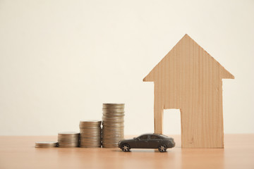Stack of coins with wood house and car,Saving money concept,new home in a housing development or...