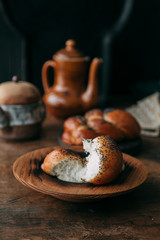 Buns and bread baking on dark wooden background. Food styling and cooking with fresh ingredients.