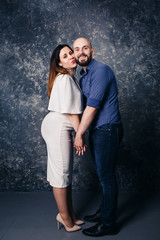 young pregnant couple holding hands and smiling.