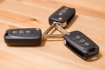 Three wireless car keys on wooden background